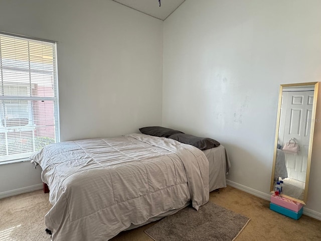 carpeted bedroom with lofted ceiling