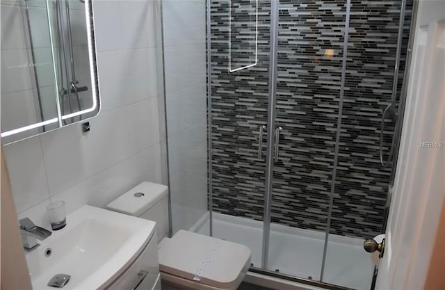 bathroom with toilet, tasteful backsplash, vanity, and a shower with shower door