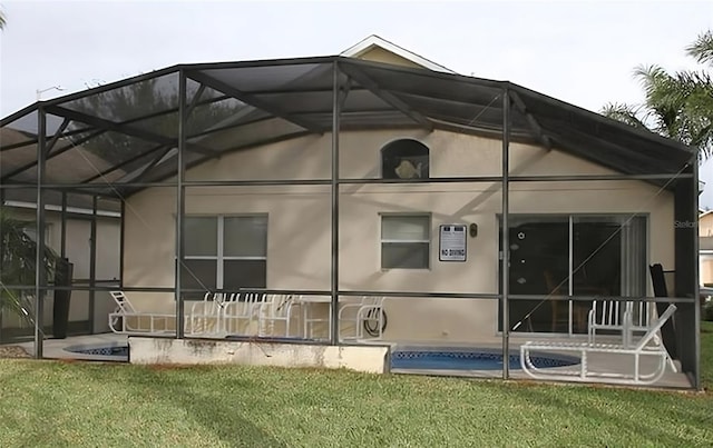 view of side of property with a lawn and a lanai