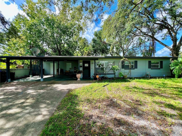 ranch-style house featuring a front yard and a carport