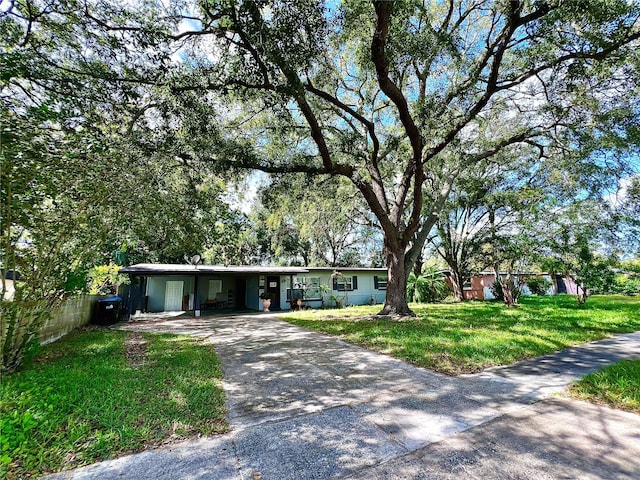 ranch-style house featuring a carport and a front lawn