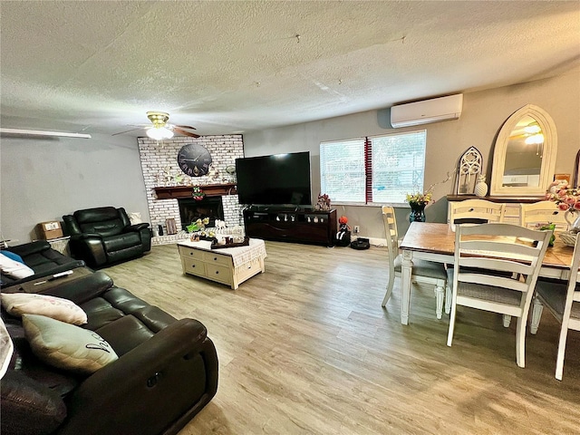 living room with hardwood / wood-style flooring, an AC wall unit, a brick fireplace, a textured ceiling, and ceiling fan