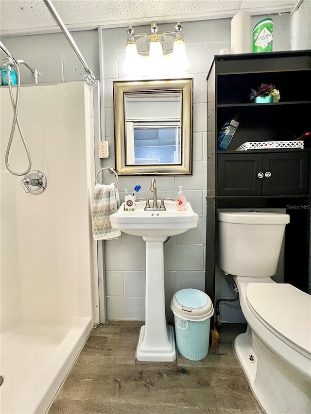 bathroom with toilet, walk in shower, and hardwood / wood-style floors