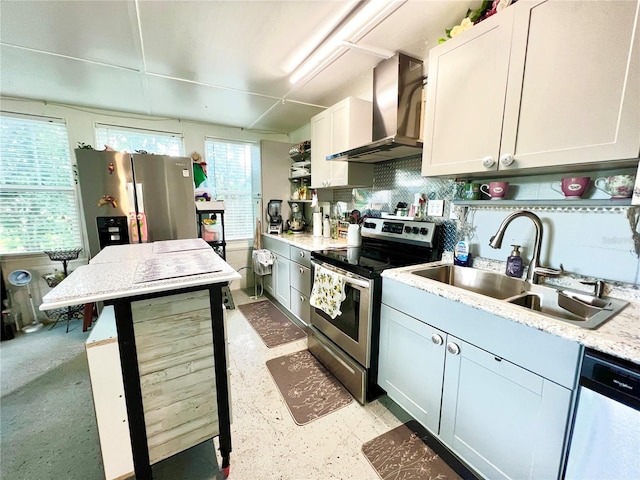 kitchen with wall chimney range hood, stainless steel appliances, sink, white cabinetry, and light stone counters