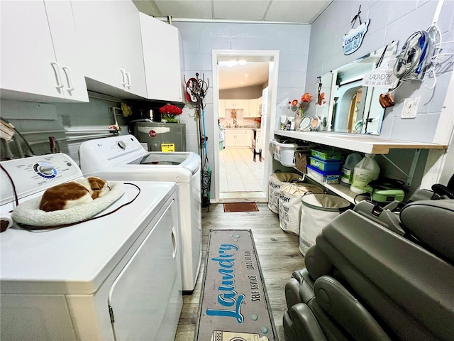 washroom featuring cabinets, light hardwood / wood-style flooring, and washer and dryer