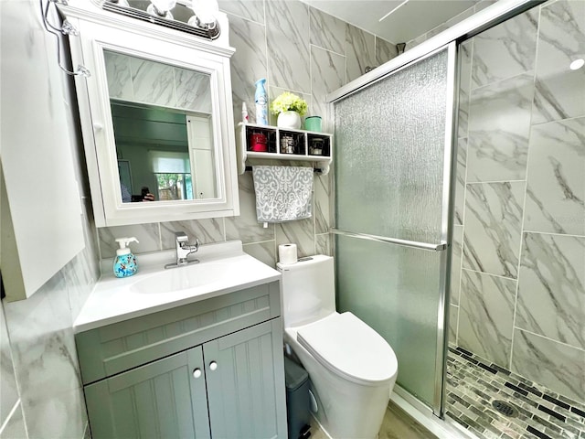 bathroom featuring toilet, walk in shower, vanity, and tile walls