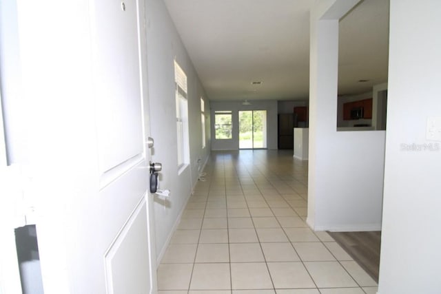 hall featuring light tile patterned floors