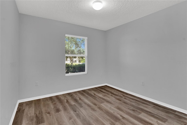 empty room featuring hardwood / wood-style floors and a textured ceiling