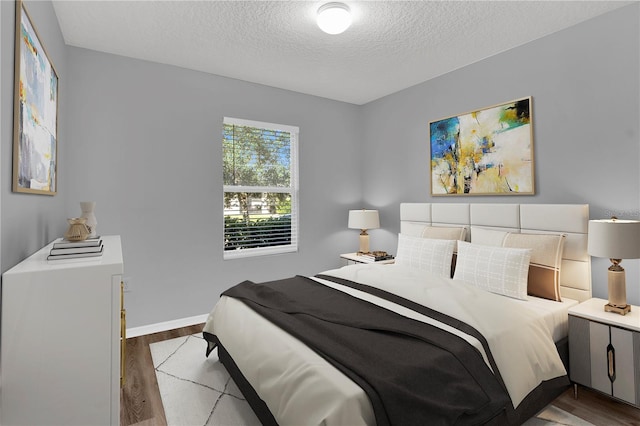 bedroom with wood-type flooring and a textured ceiling