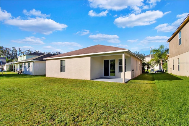 rear view of house featuring a patio and a lawn