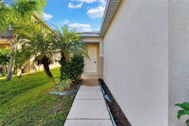 doorway to property with a lawn