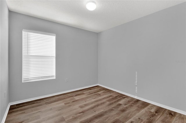 empty room featuring a textured ceiling and hardwood / wood-style flooring