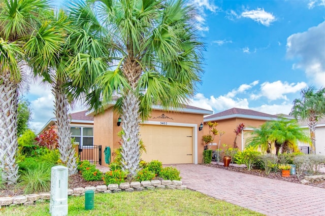 view of front of home with a garage, decorative driveway, and stucco siding