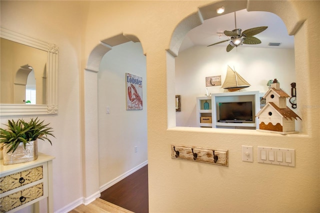 39 Tee View Pl, Rotonda West, FL 33947 - hallway featuring arched walkways, wood finished floors, and baseboards