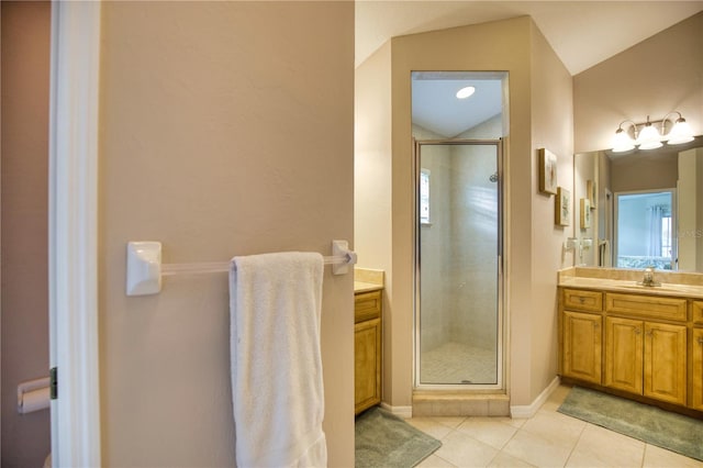 bathroom with vanity, vaulted ceiling, a shower with shower door, and tile patterned flooring