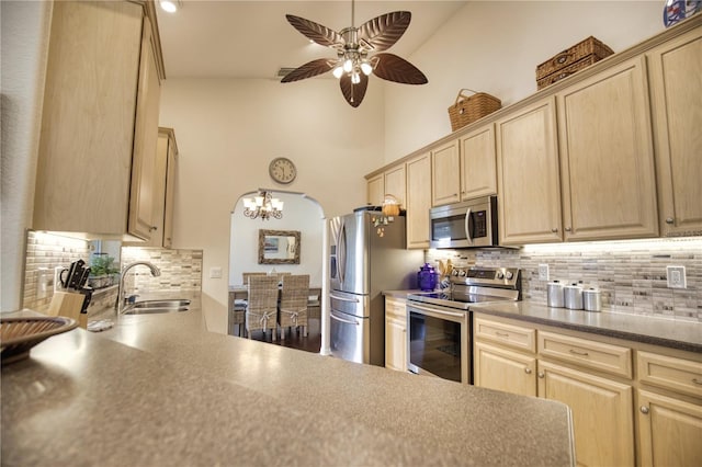 39 Tee View Pl, Rotonda West, FL 33947 - kitchen featuring stainless steel appliances, a sink, light brown cabinetry, backsplash, and high vaulted ceiling