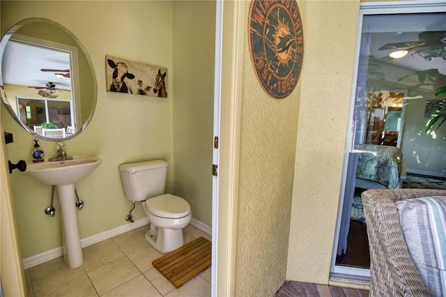 39 Tee View Pl, Rotonda West, FL 33947 - half bath featuring toilet, tile patterned floors, ceiling fan, ensuite bathroom, and baseboards