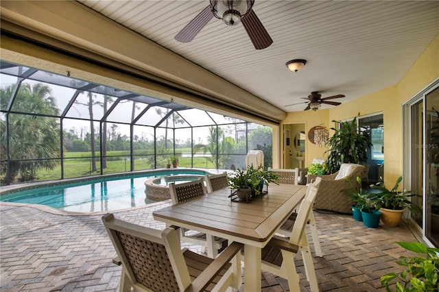 view of swimming pool featuring a patio, glass enclosure, an in ground hot tub, and ceiling fan