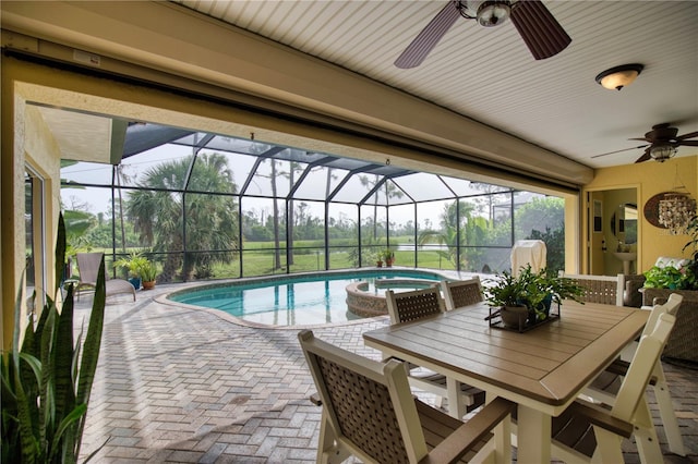 view of swimming pool featuring an in ground hot tub, a patio, glass enclosure, and ceiling fan