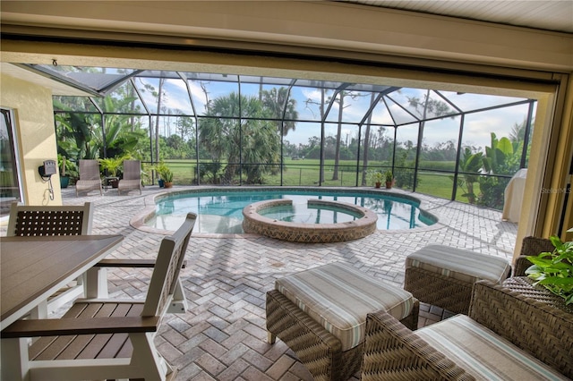 view of pool featuring a patio, an in ground hot tub, and glass enclosure