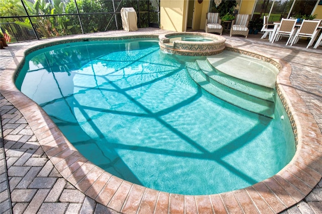 view of pool featuring a patio area, a lanai, and an in ground hot tub