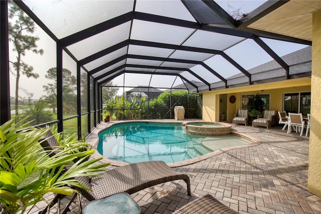 view of pool featuring a patio area, an in ground hot tub, and glass enclosure