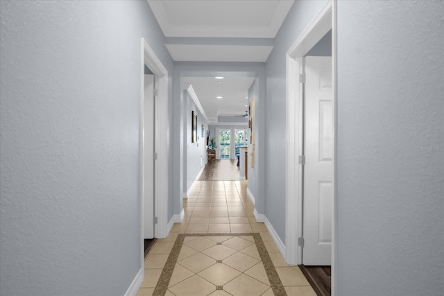 corridor featuring light tile patterned floors and crown molding