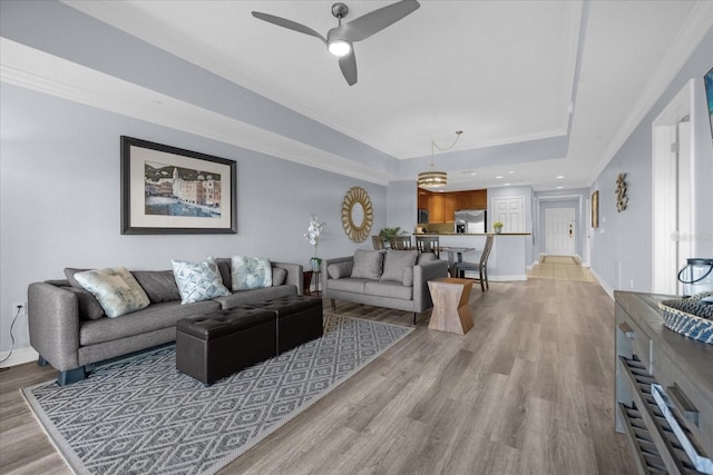 living room with ceiling fan, light hardwood / wood-style flooring, and ornamental molding