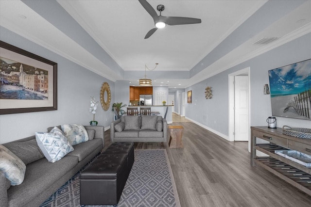 living room featuring crown molding, ceiling fan, and hardwood / wood-style flooring