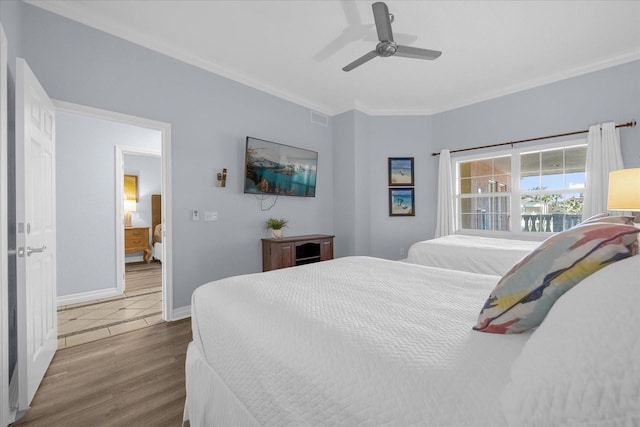 bedroom featuring ceiling fan, wood-type flooring, and ornamental molding