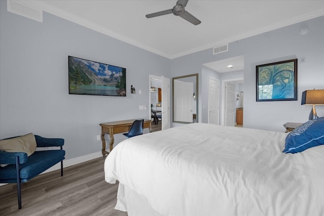 bedroom featuring connected bathroom, ceiling fan, crown molding, and wood-type flooring