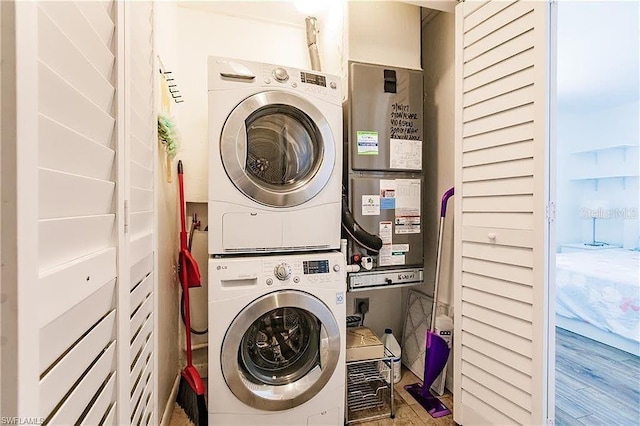 laundry room featuring stacked washer / drying machine and wood-type flooring