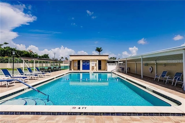 view of swimming pool with a patio and an outdoor structure