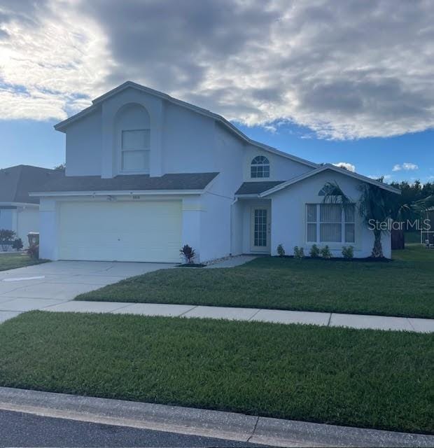 view of front of property featuring a front yard and a garage