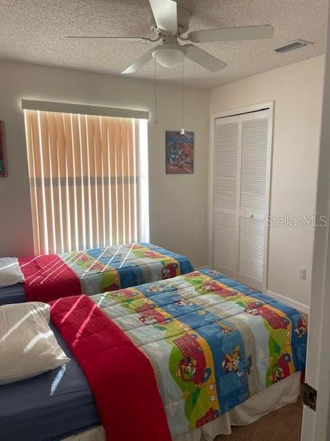 bedroom featuring a textured ceiling, ceiling fan, and a closet