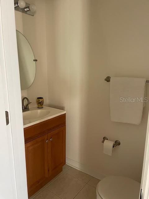 bathroom featuring toilet, vanity, and tile patterned flooring