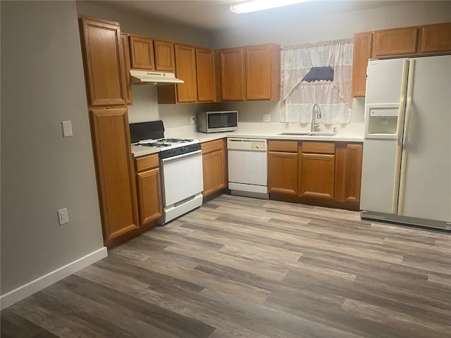 kitchen with white appliances, light hardwood / wood-style floors, and sink