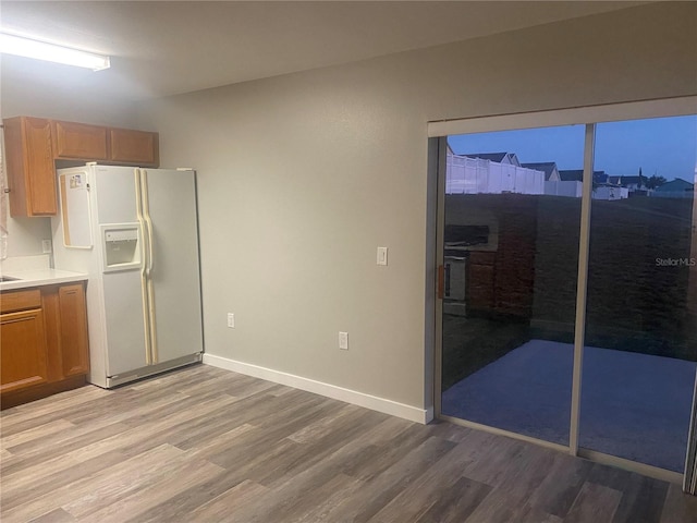 kitchen with white fridge with ice dispenser and light hardwood / wood-style flooring