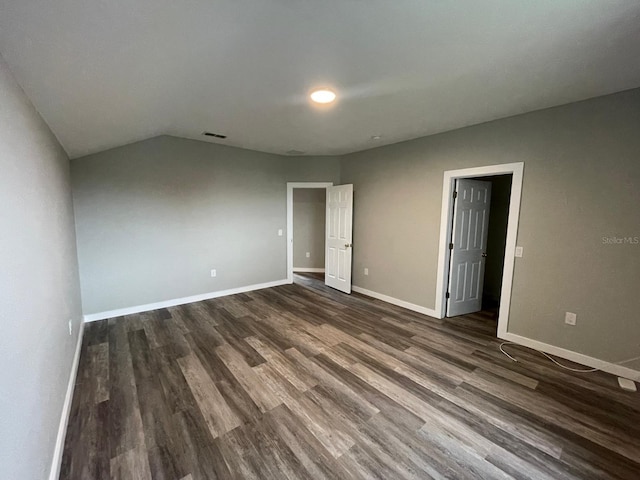 unfurnished bedroom featuring dark hardwood / wood-style flooring and vaulted ceiling