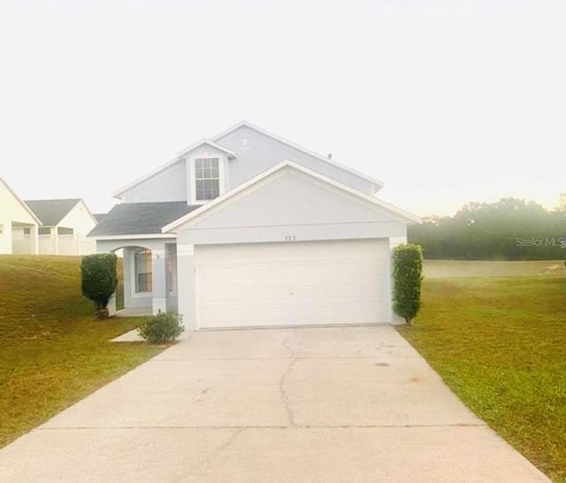 view of front of home with a front yard and a garage