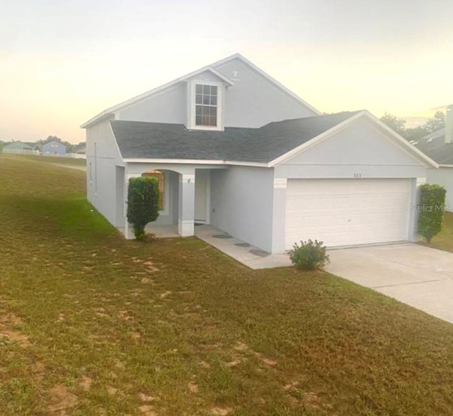 view of front of house featuring a yard and a garage