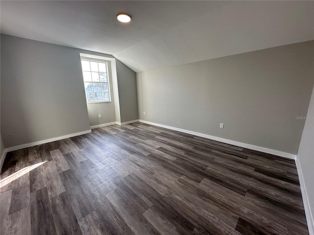 bonus room with vaulted ceiling and dark wood-type flooring