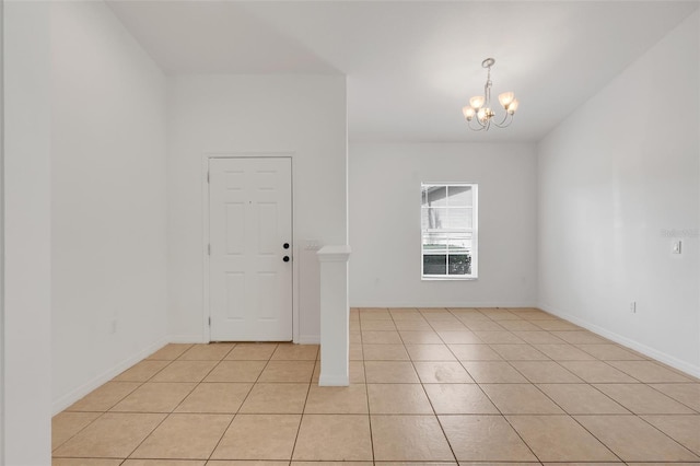 tiled foyer featuring an inviting chandelier