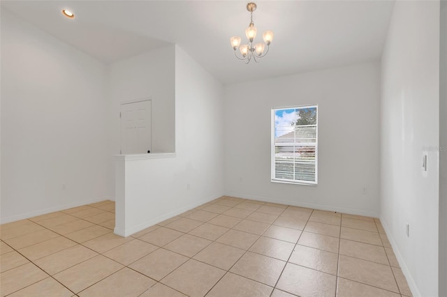 unfurnished room with a chandelier and light tile patterned floors