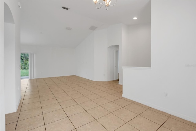 unfurnished room featuring high vaulted ceiling, light tile patterned floors, and an inviting chandelier