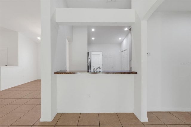 interior space featuring sink, tile patterned floors, and stainless steel fridge