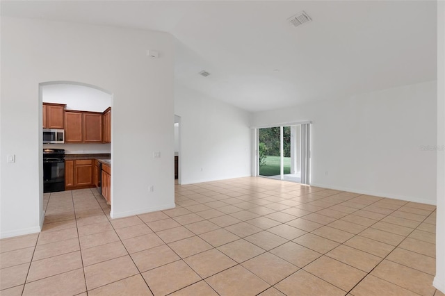 unfurnished living room featuring light tile patterned floors and lofted ceiling