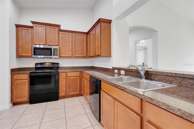 kitchen with black appliances, sink, vaulted ceiling, and light tile patterned floors