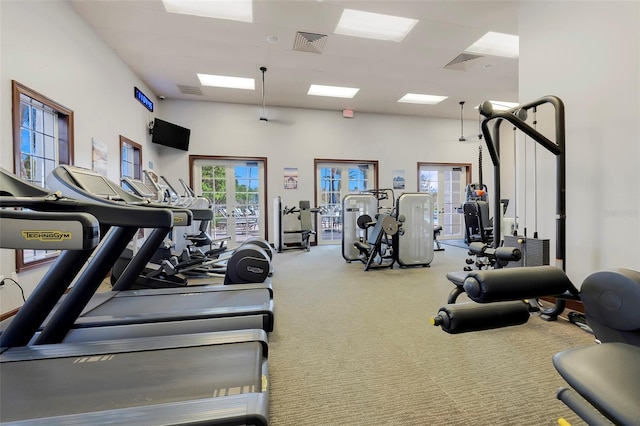 exercise room with a high ceiling and carpet flooring