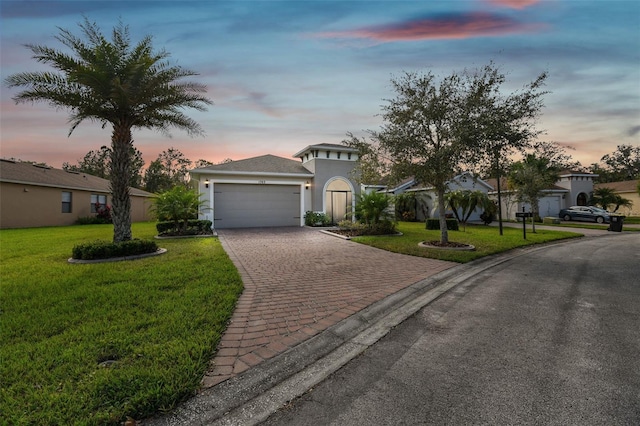 view of front of home with a garage and a lawn